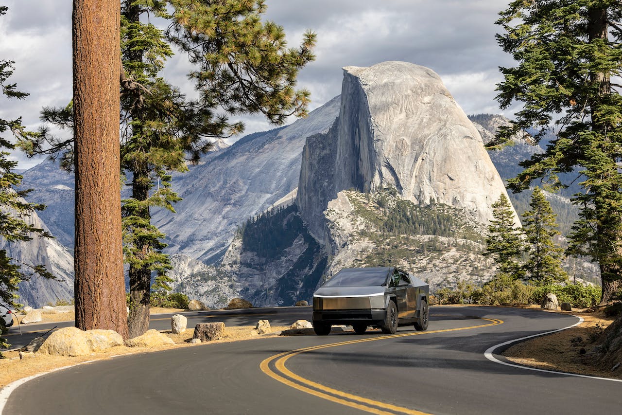 Image of Yosemite Falls. The waterfall is cascading down a rock face, and the trees in the background are reflected in the water.